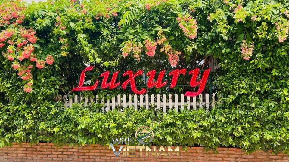 초록 덤불 위에 장식된 붉은색 럭셔리 영문 간판