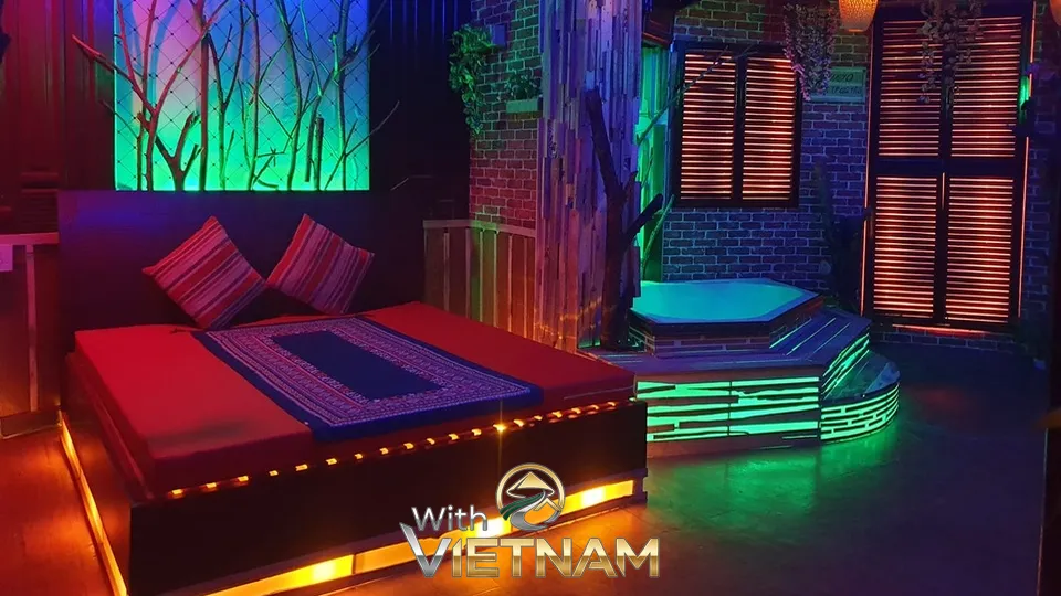 화려한 조명 아래 붉은 침대와 자쿠지가 있는 마사지룸