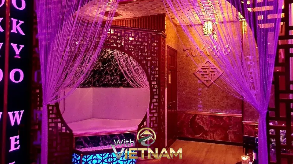 보라색 조명과 비즈 커튼으로 장식된 욕조가 있는 마사지실