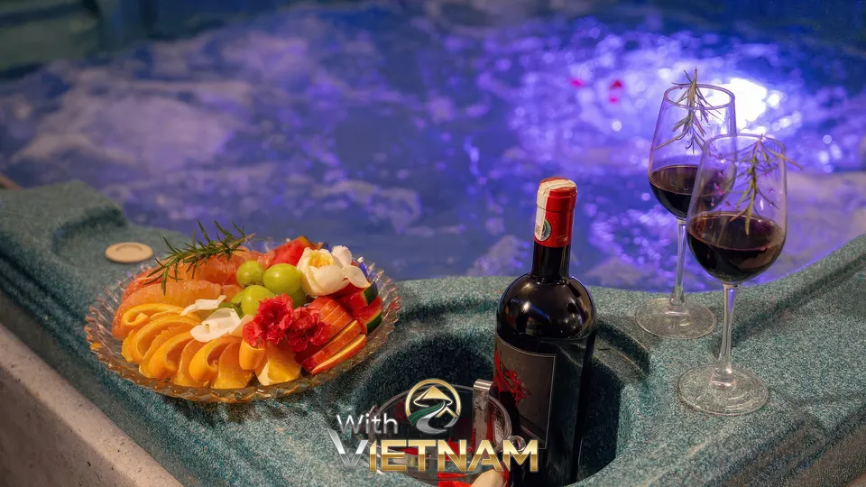 자쿠지 옆에 놓인 와인과 과일 플래터