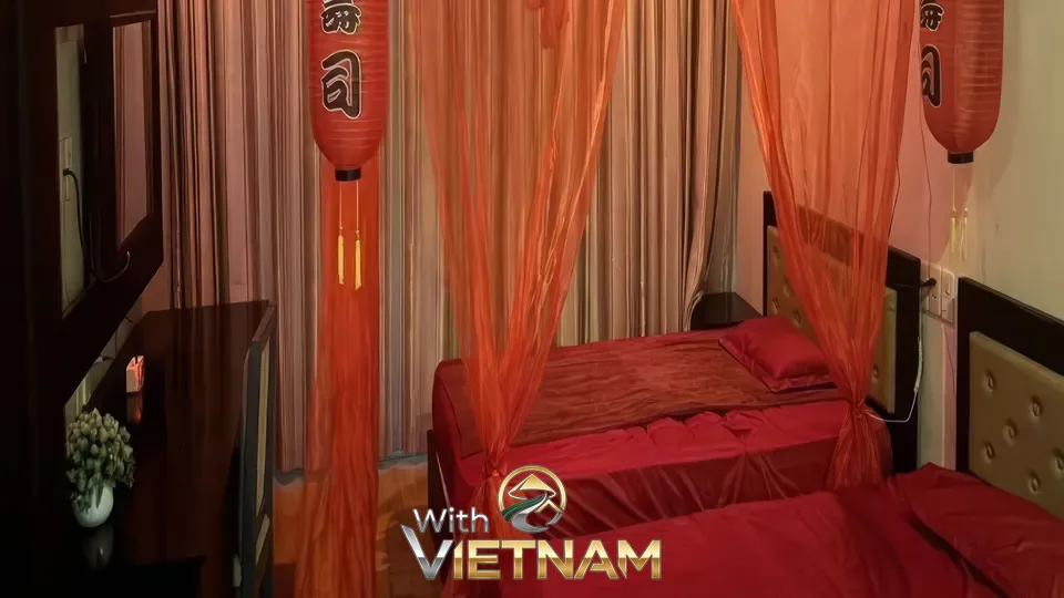 붉은 침구와 주황색 등이 있는 침실