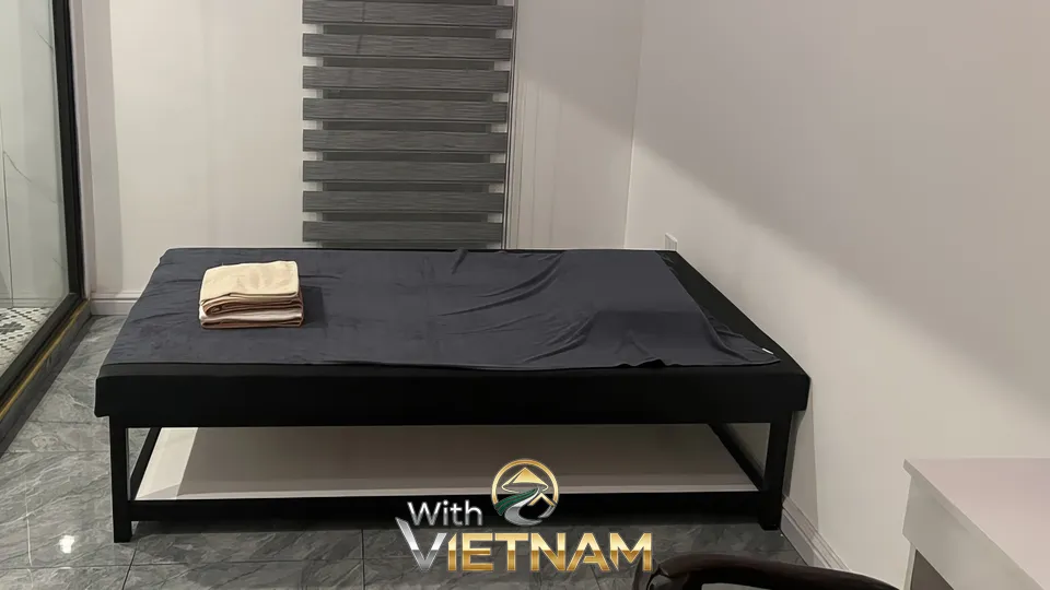 수건이 놓인 검은색 마사지 침대