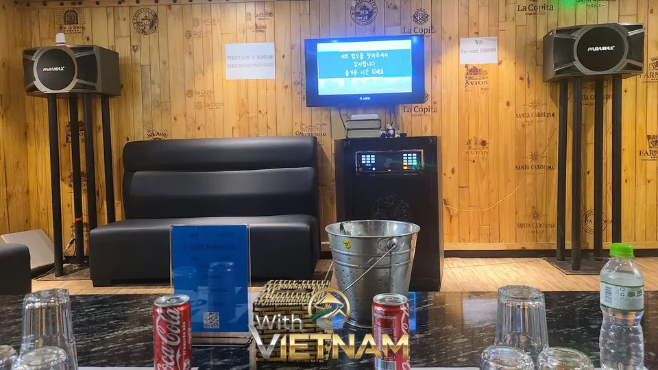 우드 톤 벽면과 블랙 소파가 있는 룸 내부