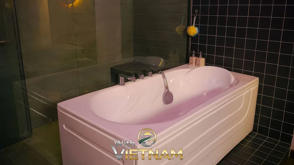 검은 타일 벽과 흰색 욕조가 있는 욕실