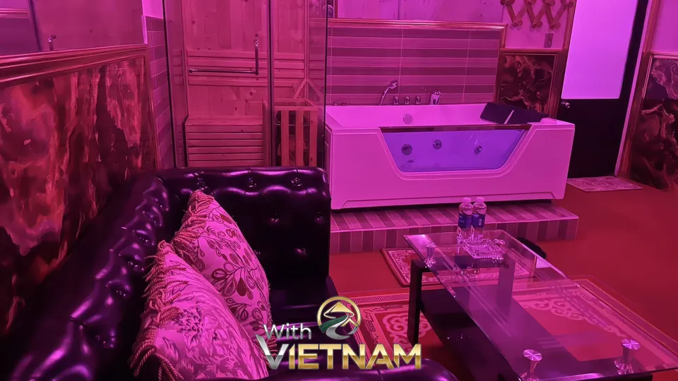 소파와 욕조가 있는 분홍색 조명의 방